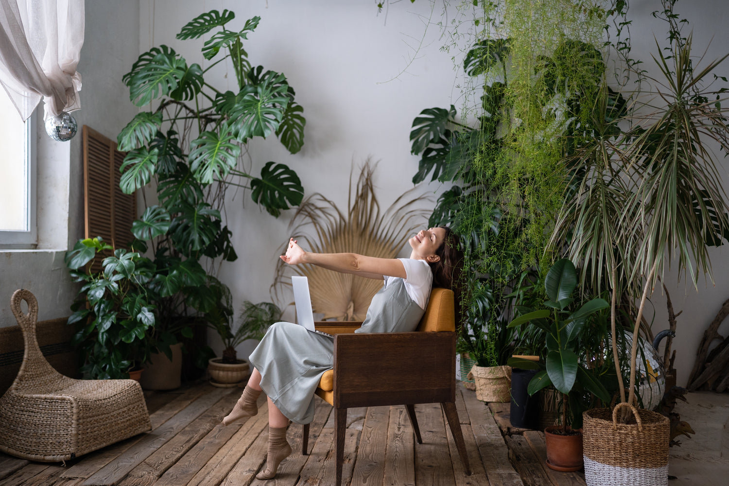 Joyful woman surrounded by thriving plants, radiating happiness and serenity.