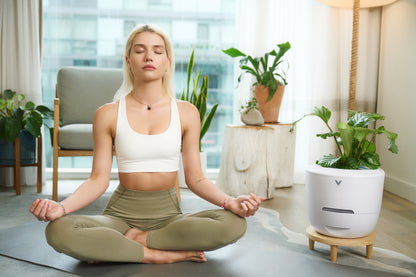 A lady practicing yoga and meditation beside Verta Eco-Friendly Air Purifier, experiencing pure, invigorating forest air for relaxation and revitalization.